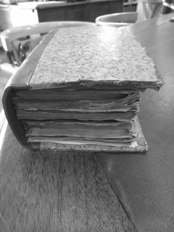 black and white photo of a very old book with no writing on the cover