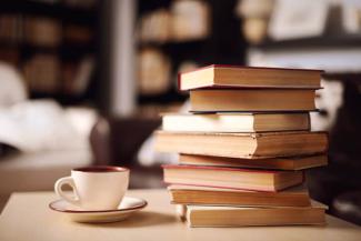 A stack of books with a coffee mug.