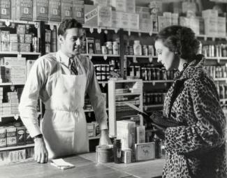 from Bloomberg Opinion - historic black and white photo of retail clerk and customer