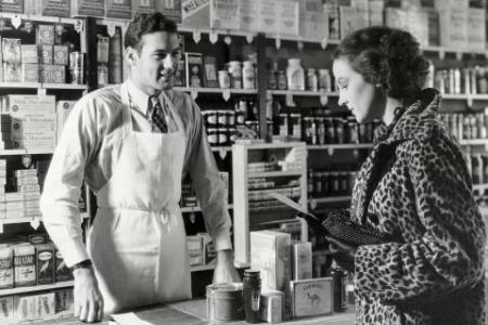 from Bloomberg Opinion - historic black and white photo of retail clerk and customer
