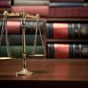 photo of a set of metal scales symbolizing justice on a table in a library
